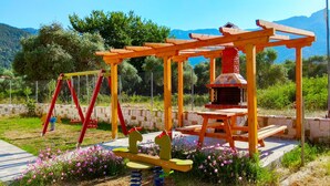 A playground with swings and a wooden climbing structure. - Porto Thassos (Thasos)