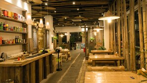 An interior with wooden tables and shelves, bamboo elements, and hanging lights. - Wuyishan Ancient Street No.3 Tea Inn (Nanping)
