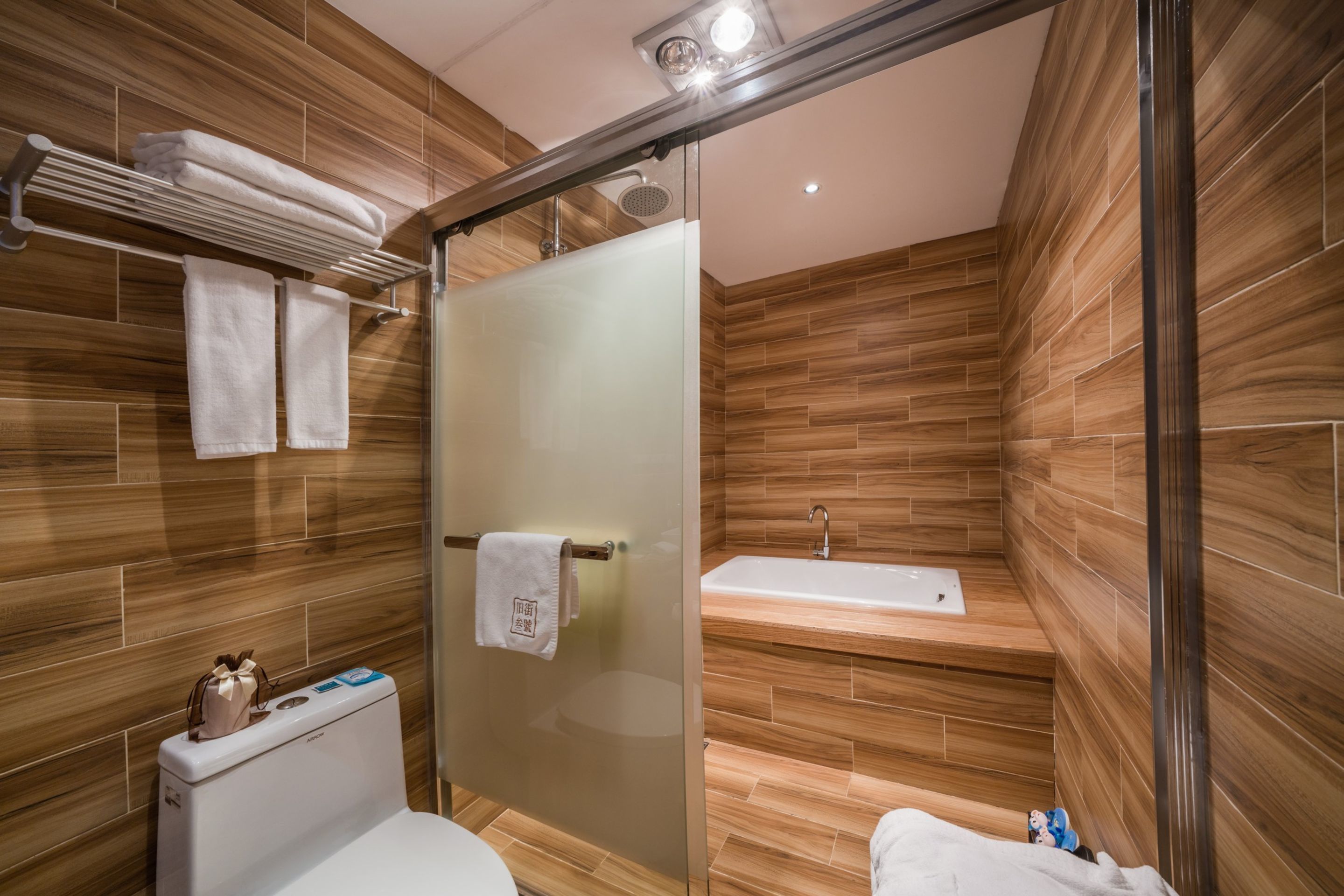 Un baño moderno con cabina de ducha de vidrio, inodoro y bañera.