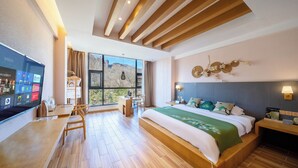 A modern hotel room with a large bed, a desk, and a TV. - Wuyishan Ancient Street No.3 Tea Inn (Nanping)