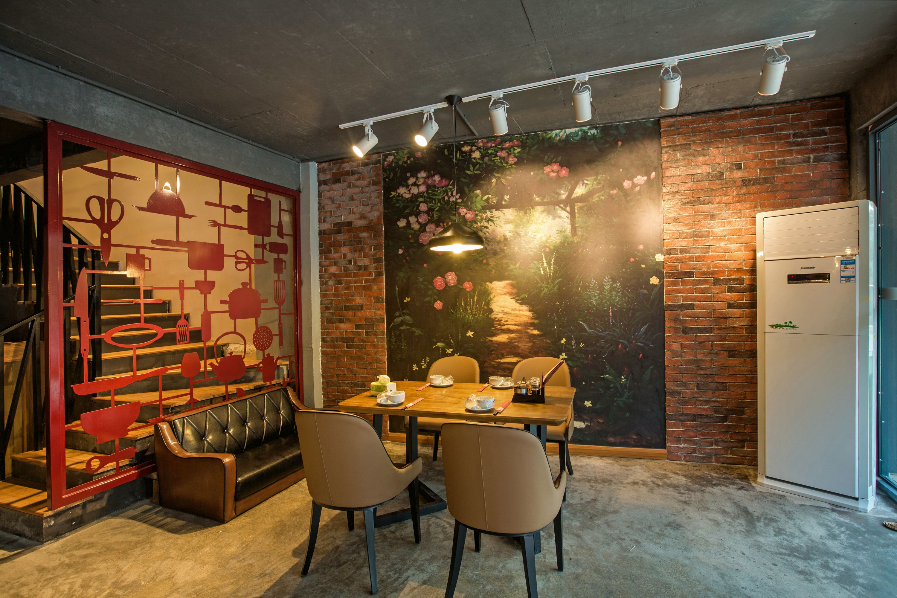 A dining area with a brick wall mural, a wooden table, and leather seating.