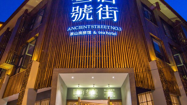 A hotel entrance with a sign reading "Ancient Street No.3 Tea Mountain Hotel". - Wuyishan Ancient Street No.3 Tea Inn (Nanping)