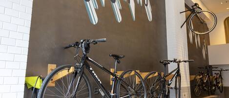 A bike rental station with bicycles mounted on a wall and a sign indicating rental prices.