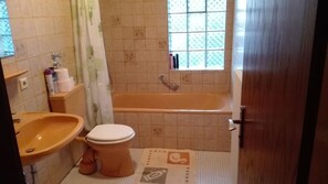 Chuveiro, toalhas de banho, sabonete, papel higiênico