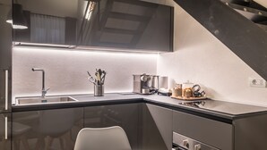 Een moderne keuken met een ingebouwde kookplaat, een spoelbak en een koffiezetapparaat.
