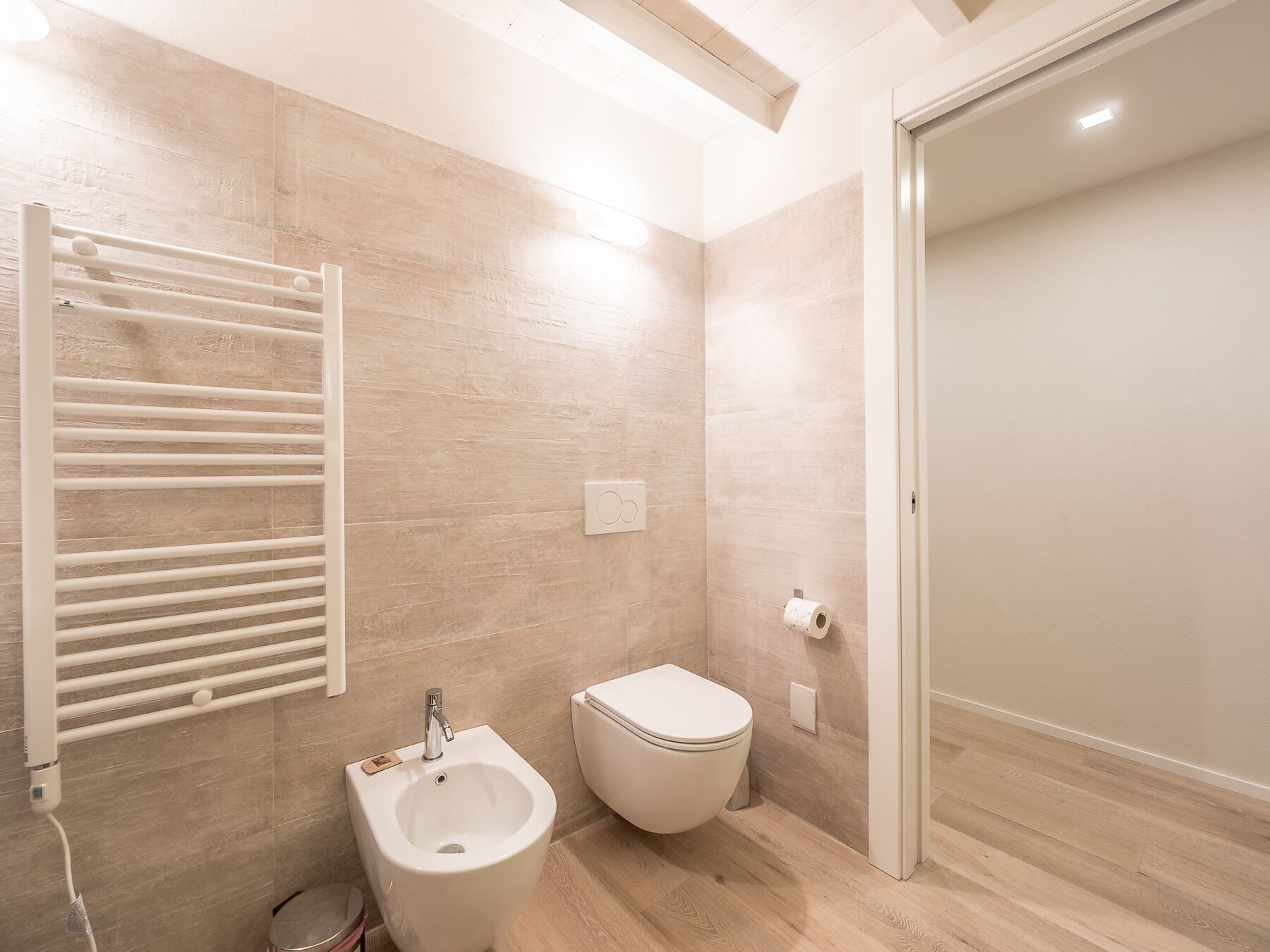 Ein modernes Badezimmer mit einer Bidet, Toilette und einem Handtuchhalter.