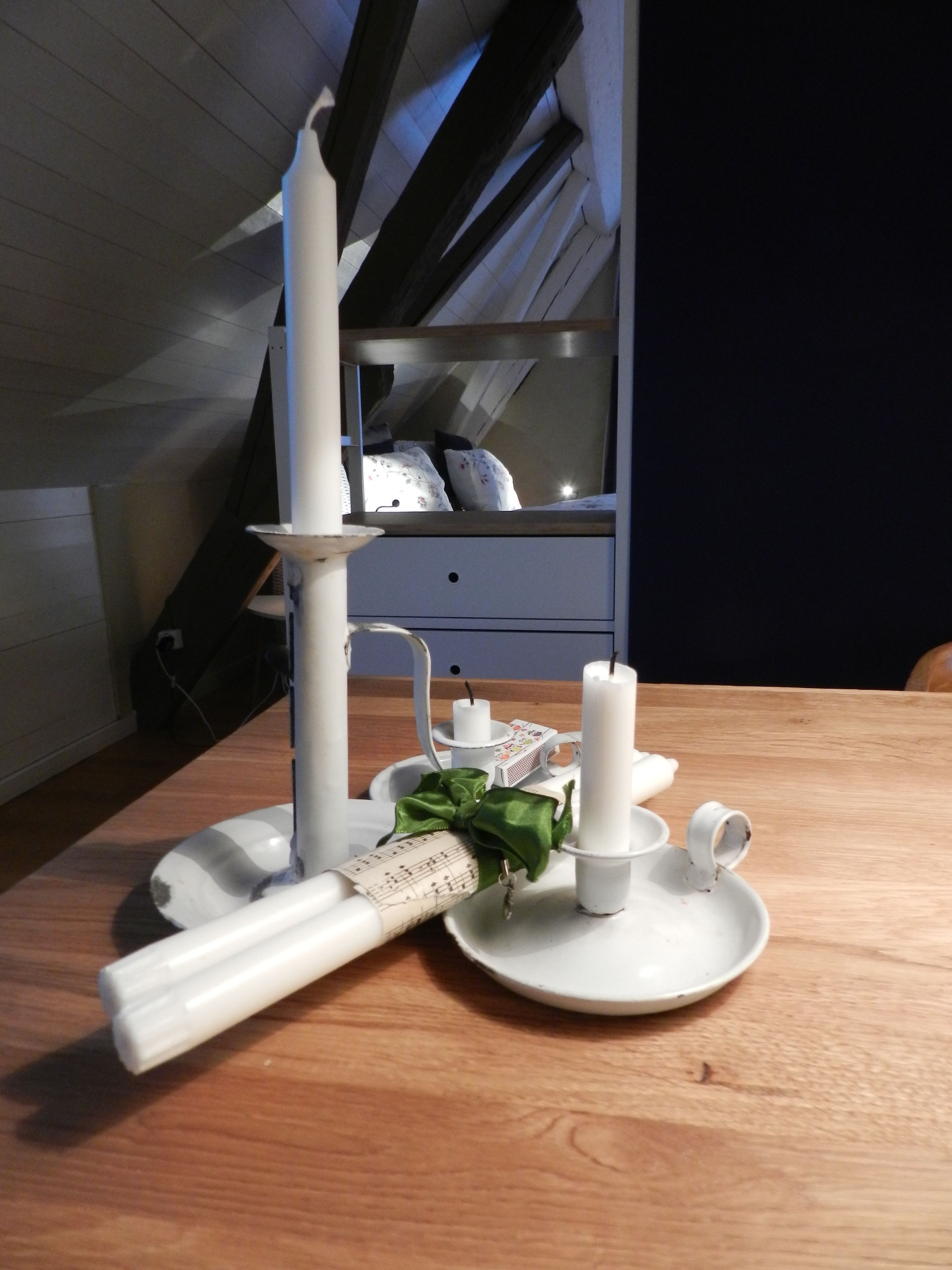 Una mesa de comedor con una vela, una partitura musical y un lazo decorativo.