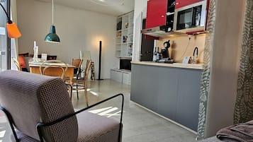 Una cocina moderna con gabinetes grises, una sección superior roja y un microondas integrado.