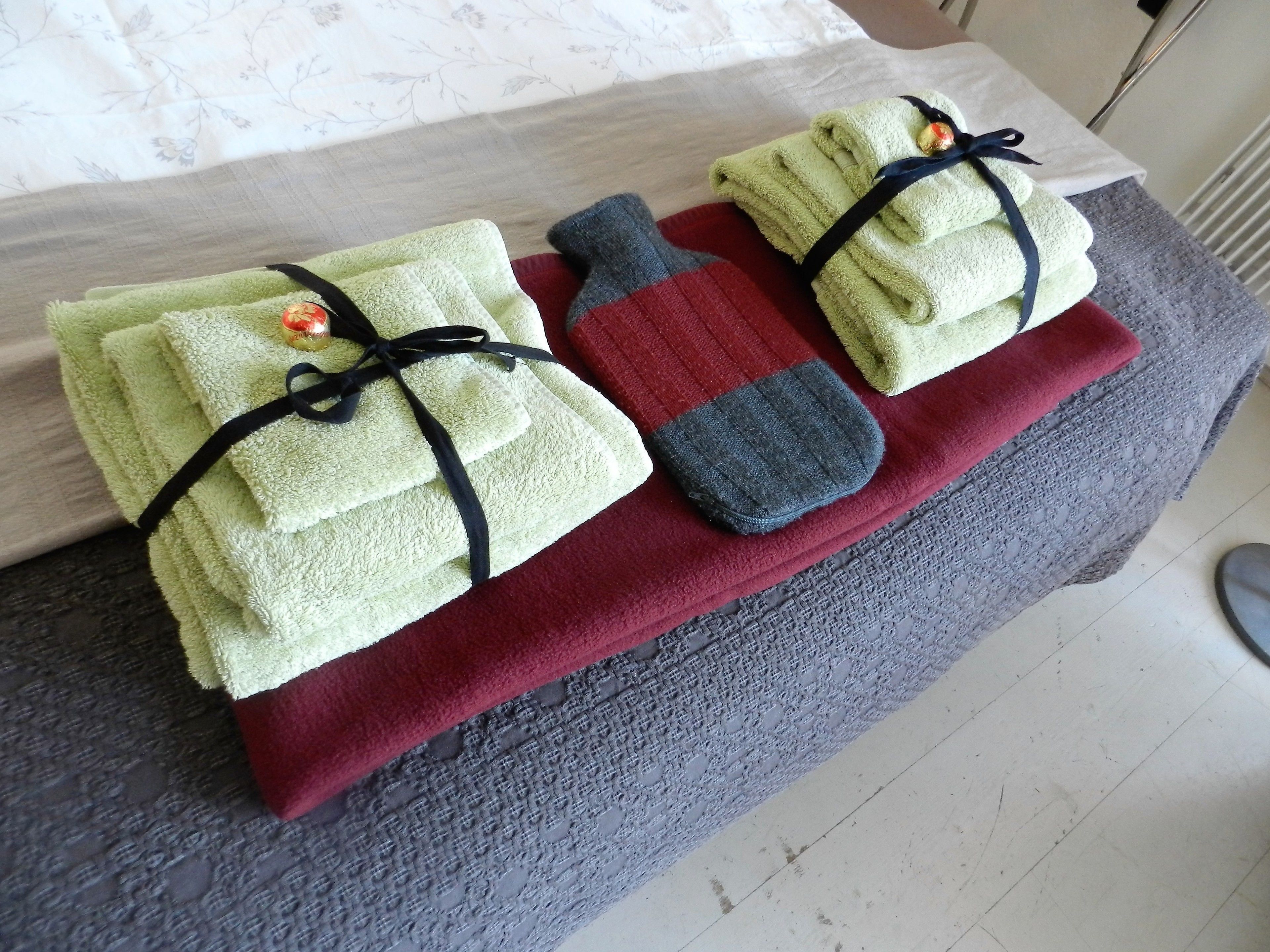 A neatly arranged set of towels and a bath sponge on a table.
