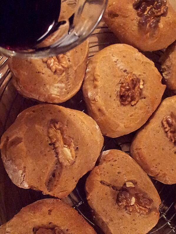 A tray of freshly baked cookies with walnuts on top, placed on a wire rack.