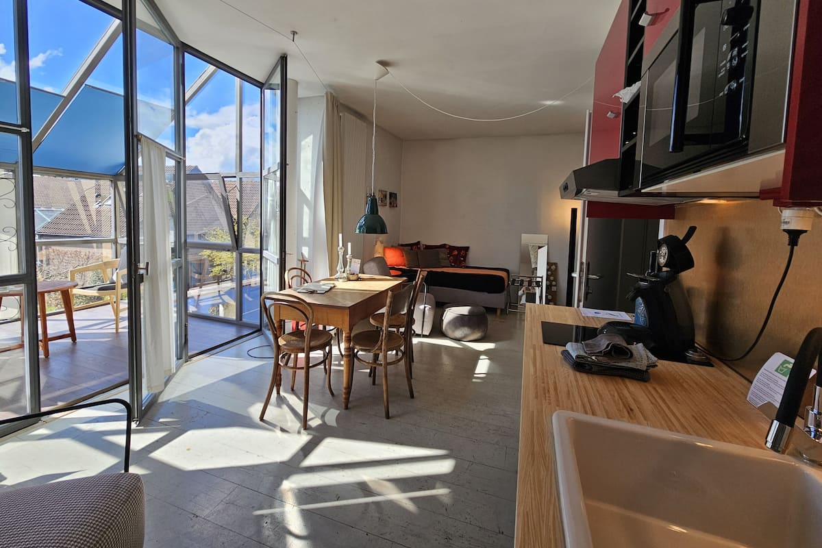 Een moderne keuken met een eethoek, grote ramen en uitzicht op het buitengebied.