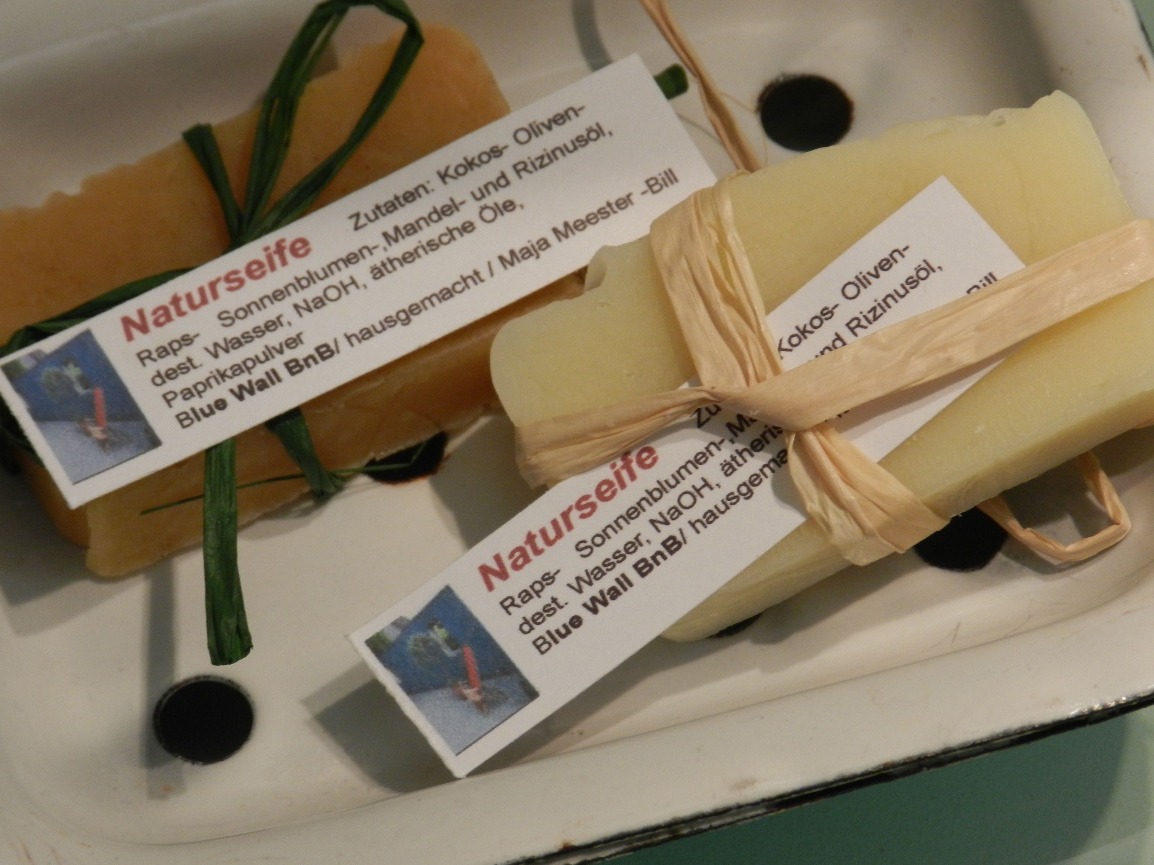A box containing several bars of soap with labels indicating ingredients like Kokos-Öl, Mandel-, and Rizinusöl.
