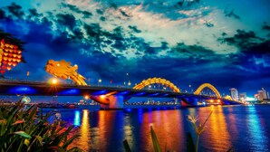 Een brug met verlichte bogen en een stadsachtergrond.