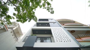 Een meerhoog gebouw met balkons, een geometrisch gevelontwerp en een uitzicht op de lucht.