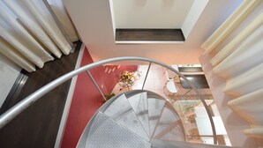 A modern interior with a spiral staircase, a red carpet, and a ceiling light fixture. - Mell-Theater 1102 (Osaka)