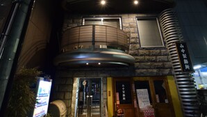 A multi-story building with a modern design, featuring a spiral staircase and a stone facade. - Mell-Theater 1102 (Osaka)
