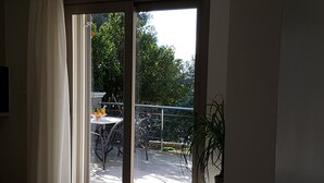 Una stanza con una porta scorrevole in vetro che si apre su un patio esterno.