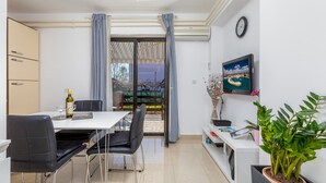 Un comedor moderno con una mesa, sillas y una planta en maceta.