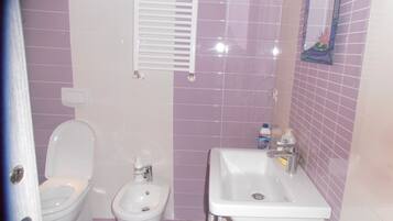 Een haardroger, handdoeken, shampoo, toiletpapier