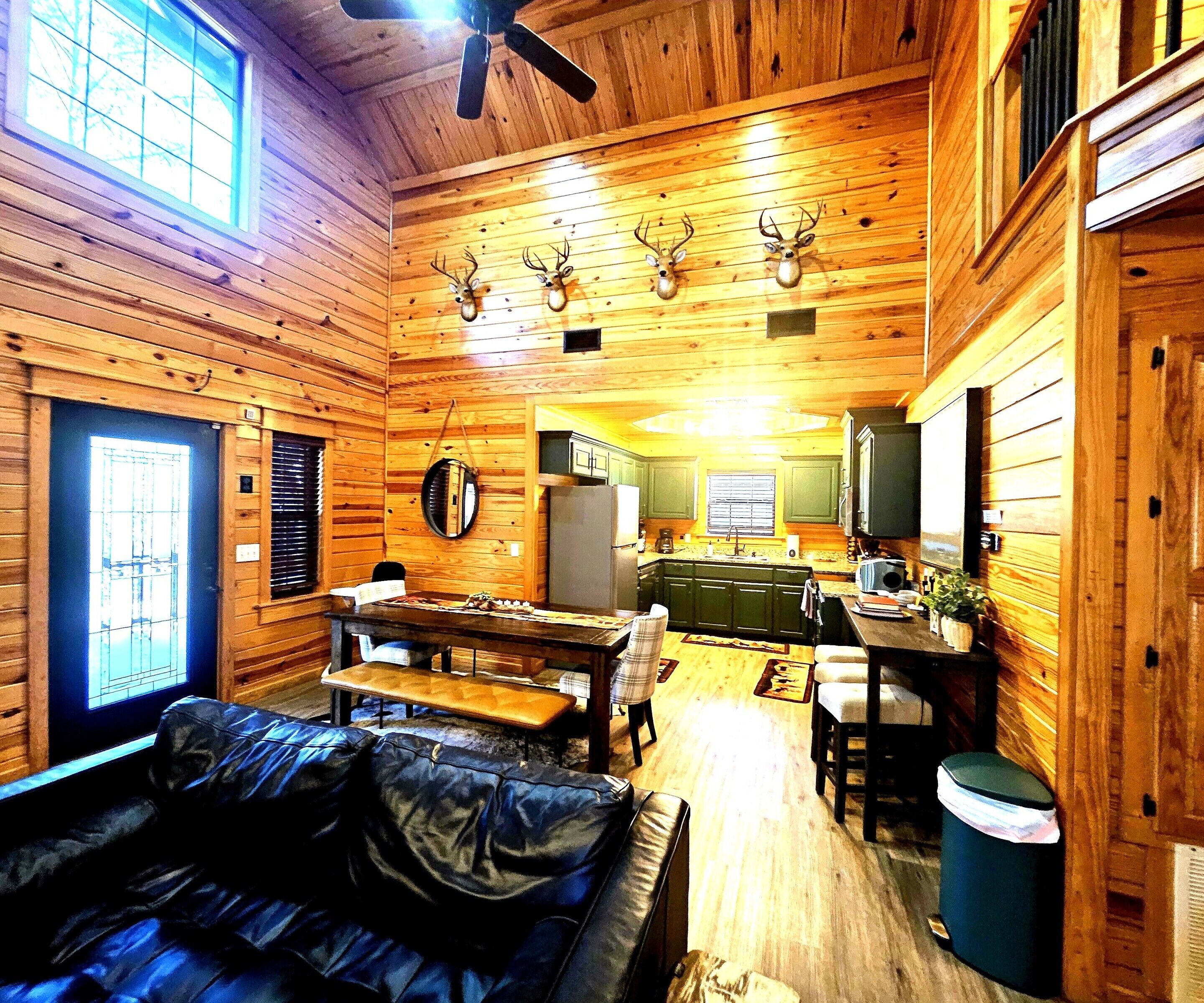 L’intérieur d’une cabane est aménagé avec du bois, et comprend un coin repas, une cuisine et un salon avec un canapé.