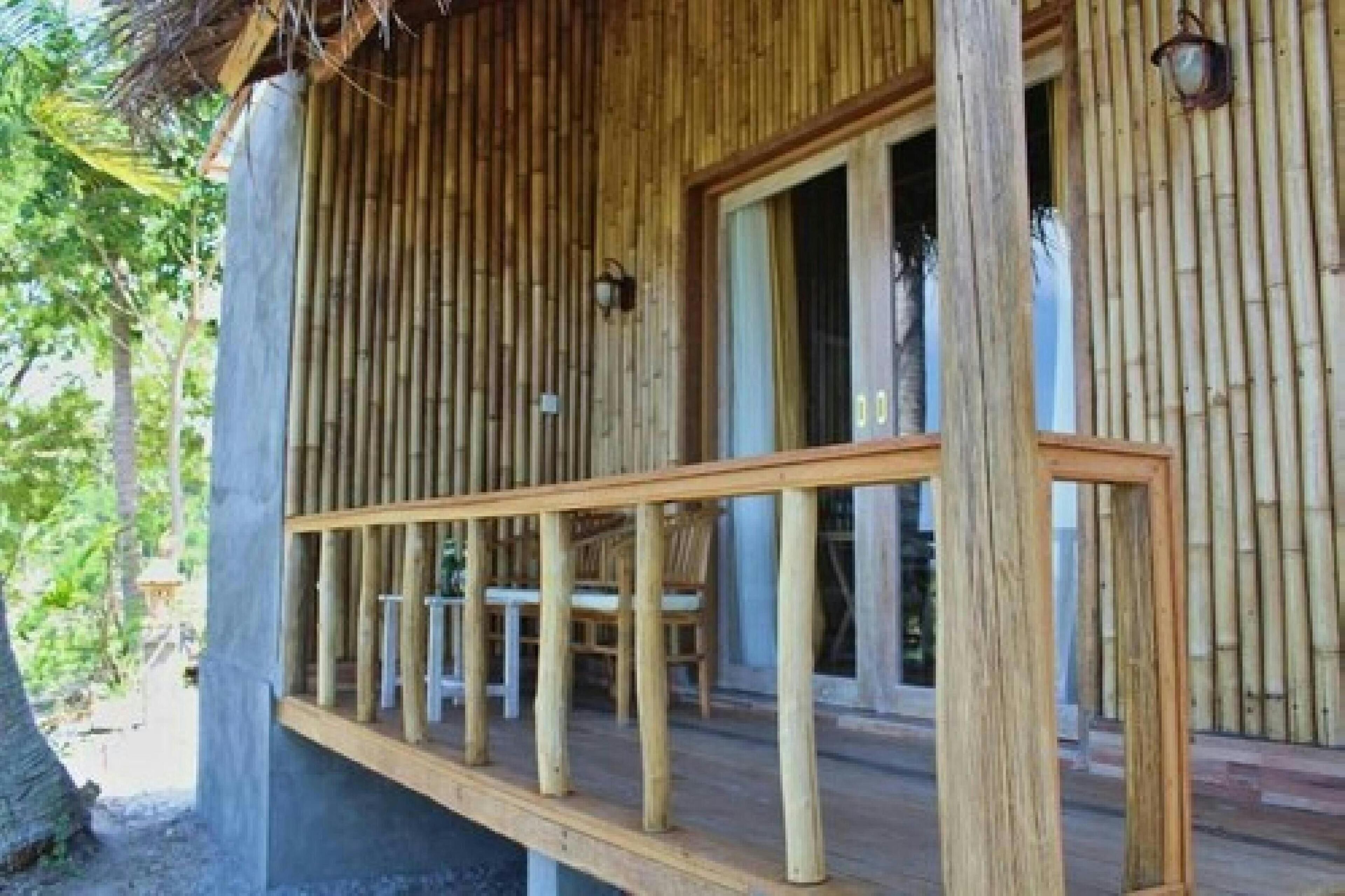 Une terrasse en bois avec une rambarde, une table et des chaises.