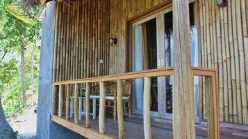 Une terrasse en bois avec une rambarde, une table et des chaises.