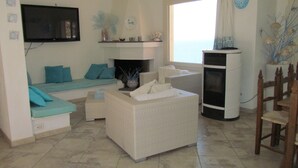 Un salon avec un canapé, une table basse, une cheminée et un téléviseur.