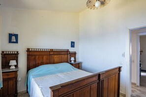 A bedroom with a wooden bed, bedside tables, and a nightstand.
