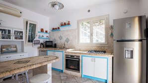 Een keuken met een centraal eiland, een koelkast, een fornuis en een magnetron.