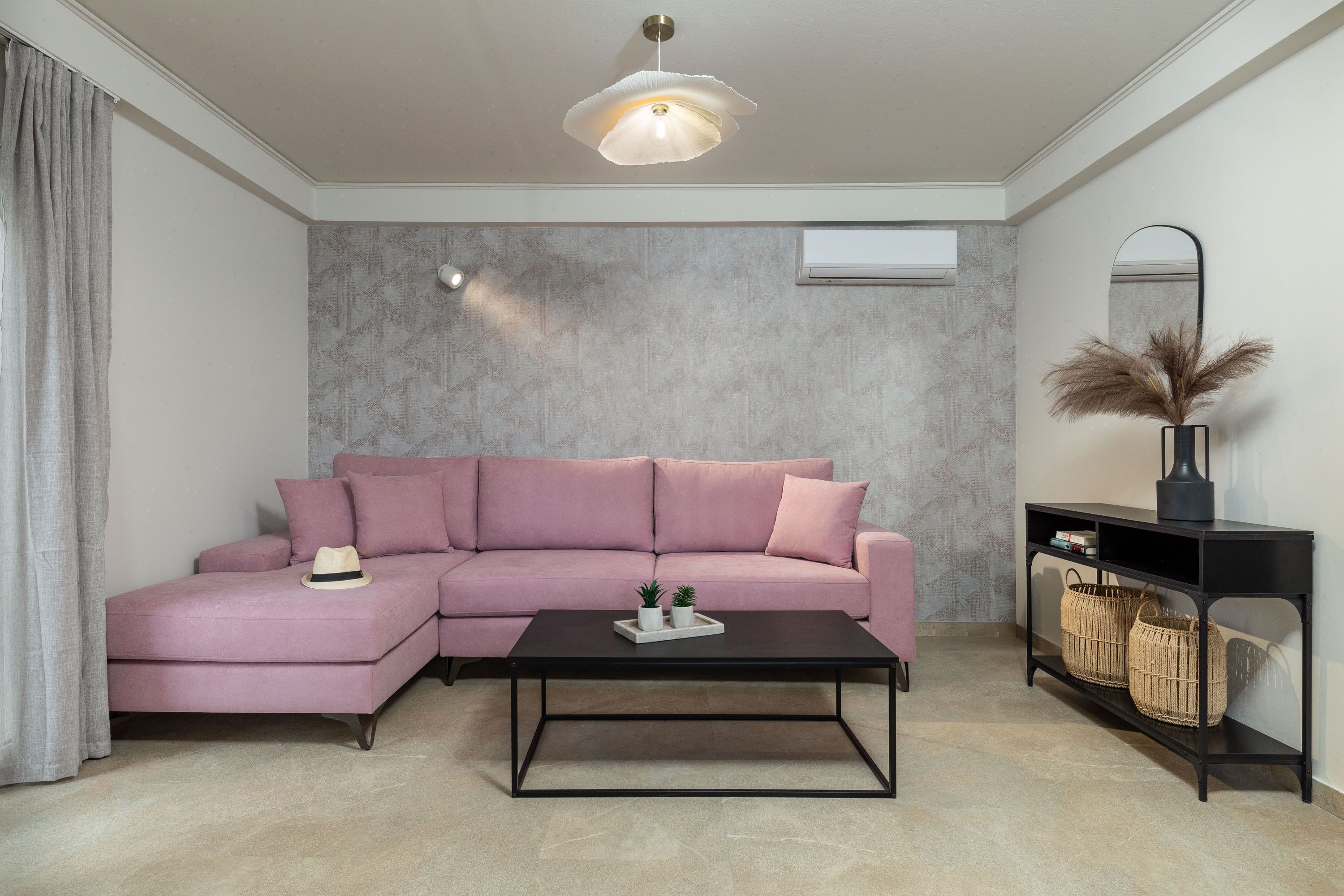 A modern living room with a sectional sofa, a coffee table, and a console table with baskets.