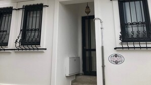 Un edificio de dos pisos con fachada de madera, molduras blancas y ventanas con marcos negros.