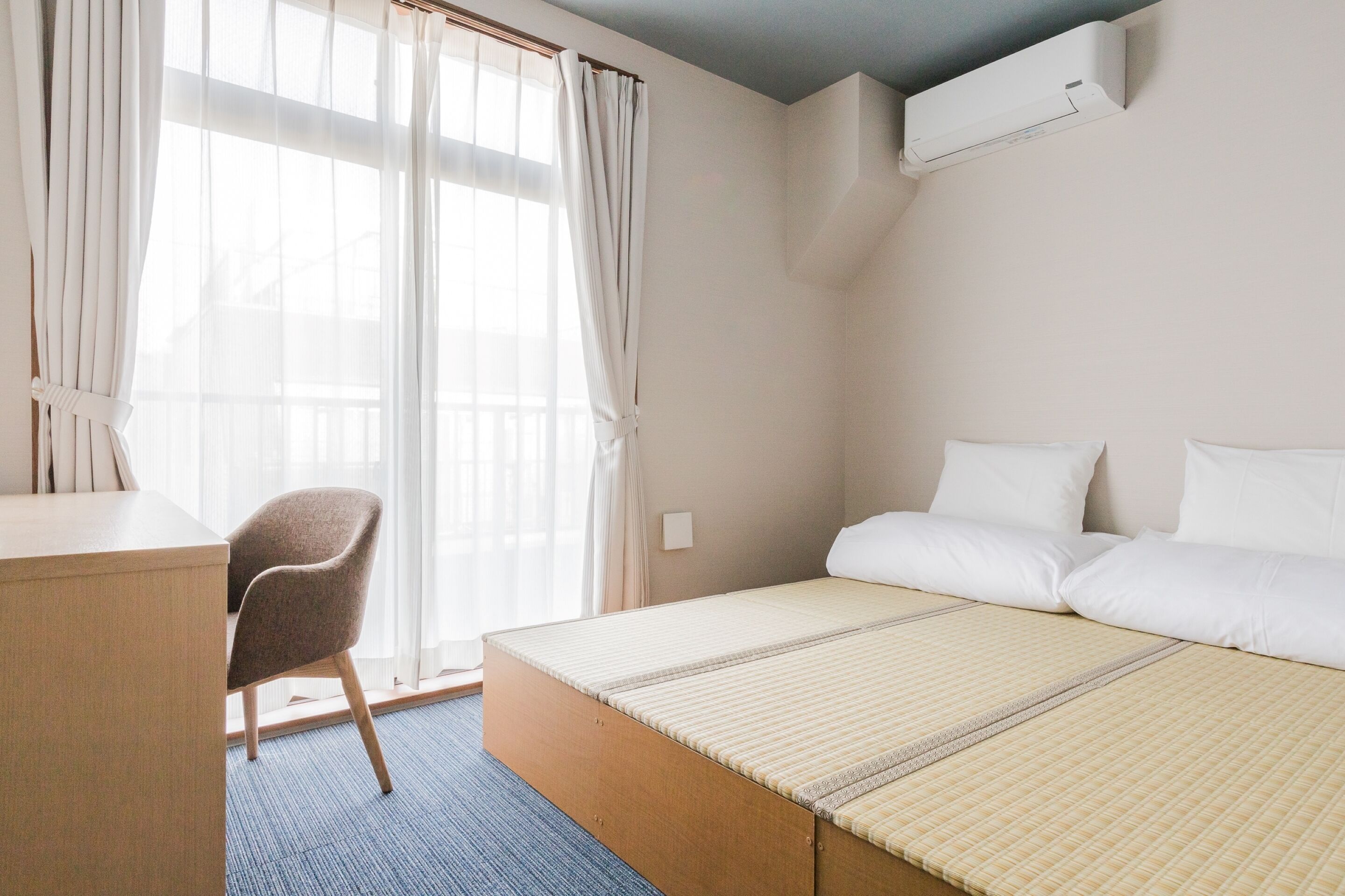 Une chambre d’hôtel avec un lit, un bureau et une chaise.