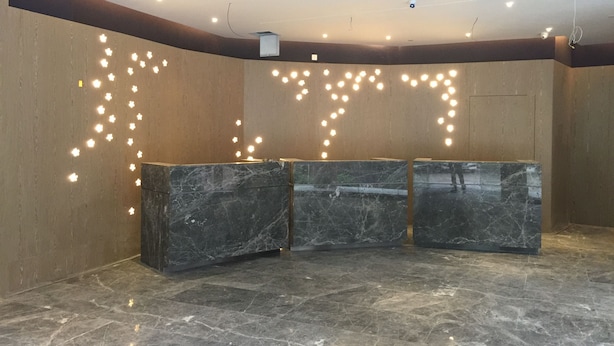 A reception area with marble counters, a high ceiling with recessed lighting, and a plain wall. - Lifu Hotel Shachong Metro Branch (Guangzhou)