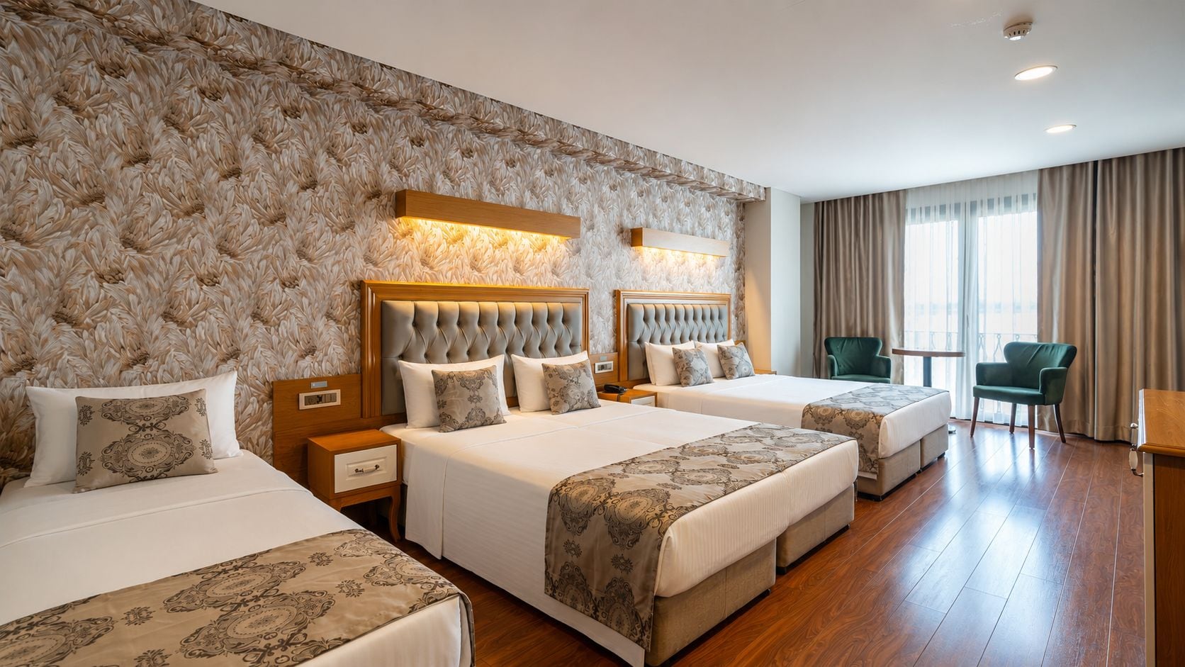 Una habitación de hotel con dos camas, un área de descanso y vistas a la ciudad.