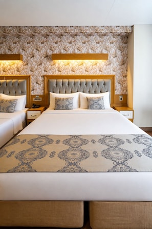 A double bed with a patterned bedspread, a tufted headboard, and bedside lamps. - Eliza Hotel (Istanbul)