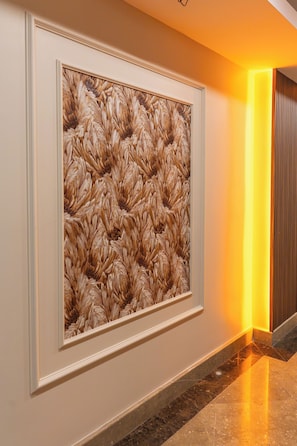 A hallway with a framed artwork on the wall and a modern light fixture. - Eliza Hotel (Istanbul)
