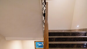 A staircase with a wooden handrail and metal balusters, leading to a landing with a framed picture. - Eliza Hotel (Istanbul)