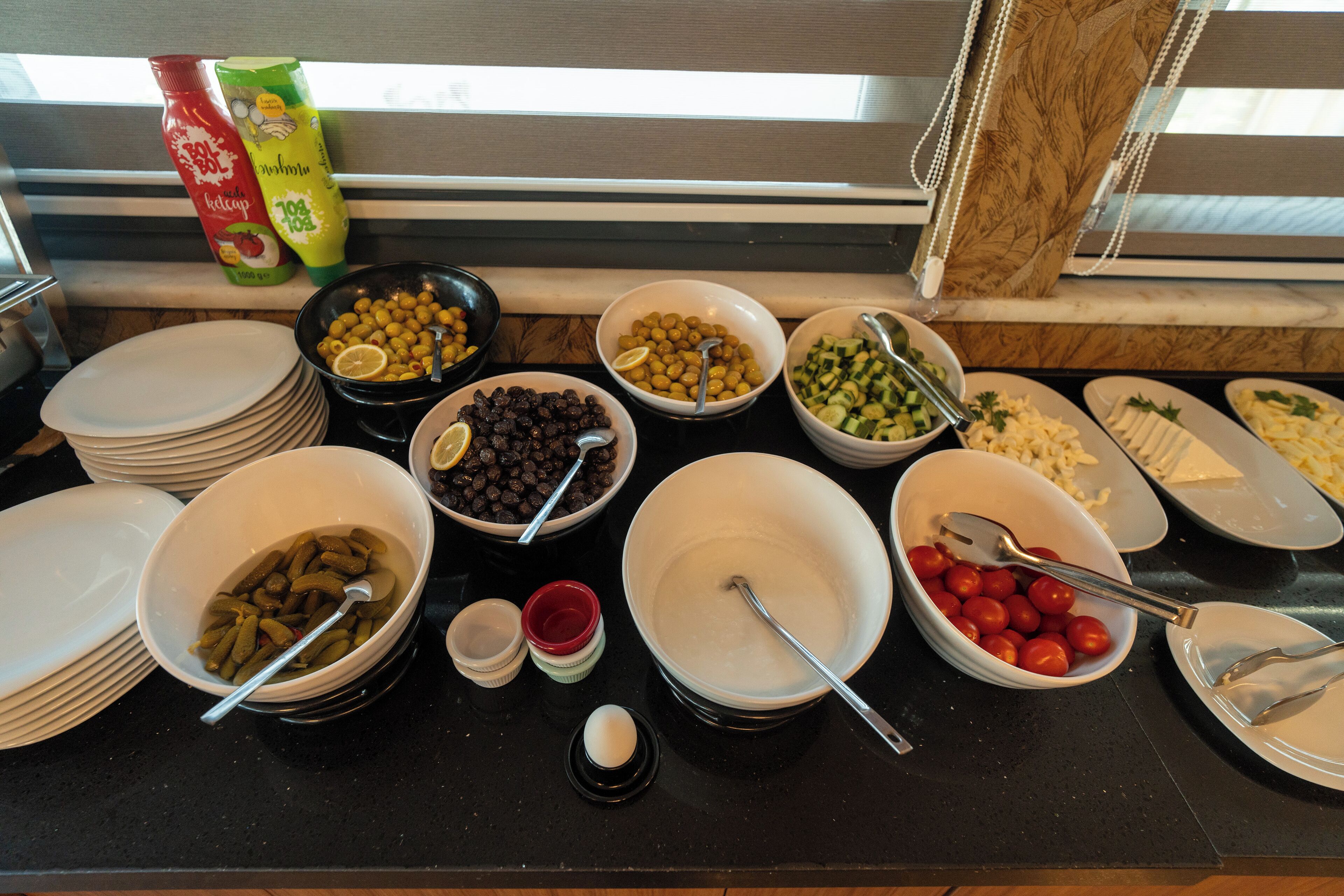 A buffet table with various food items and condiments.
