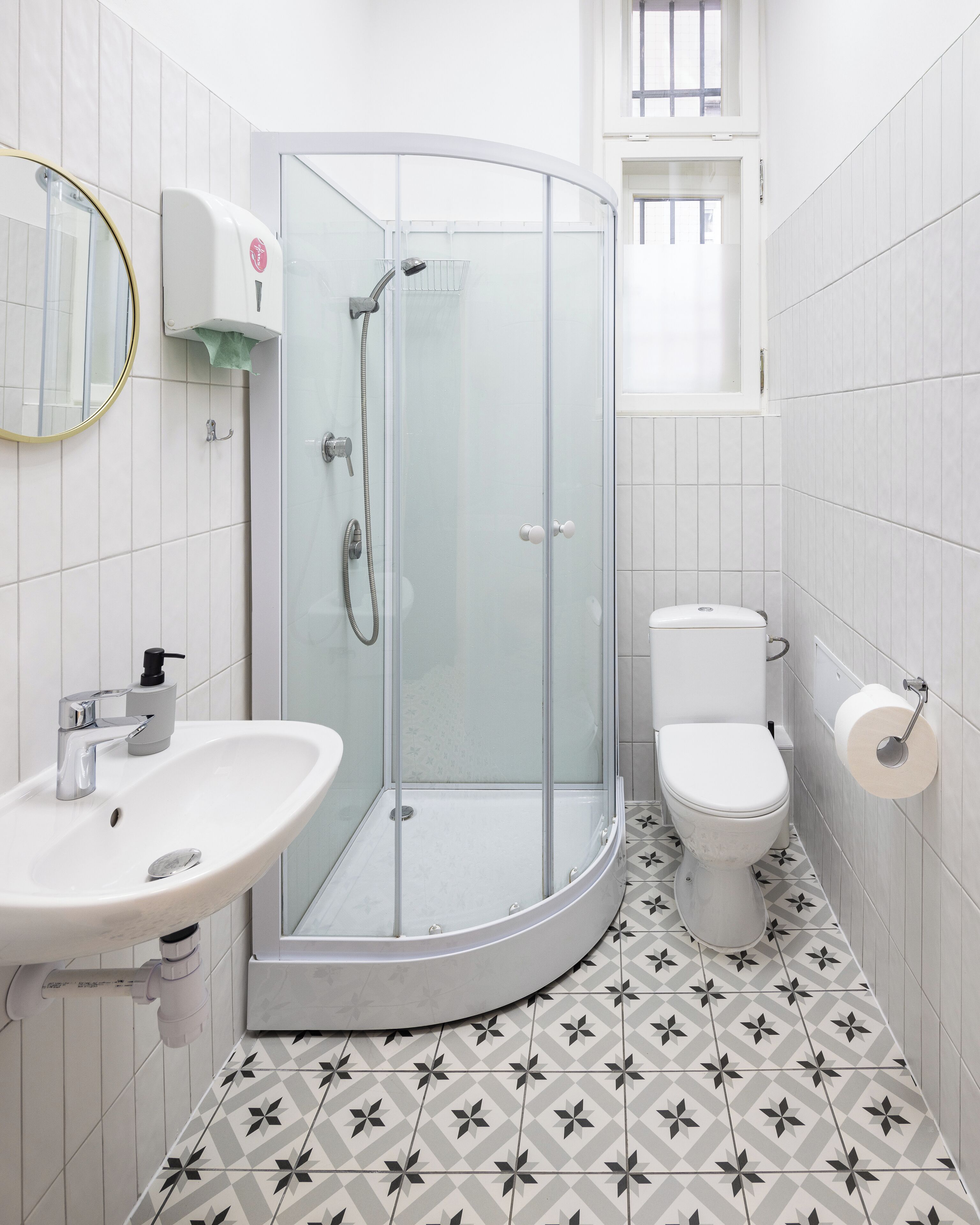 Un baño con ducha acristalada, lavamanos e inodoro.