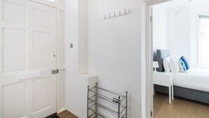 Una camera da letto con un letto, un comodino e una mensola a parete.