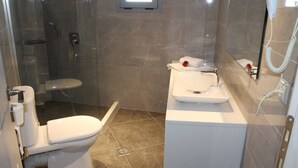 Een badkamer met toilet, douche en wastafel.