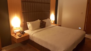 A hotel room with a large bed, two bedside tables with lamps, a telephone, and a wall-mounted light. - The Classik Fort (Kanayannur)