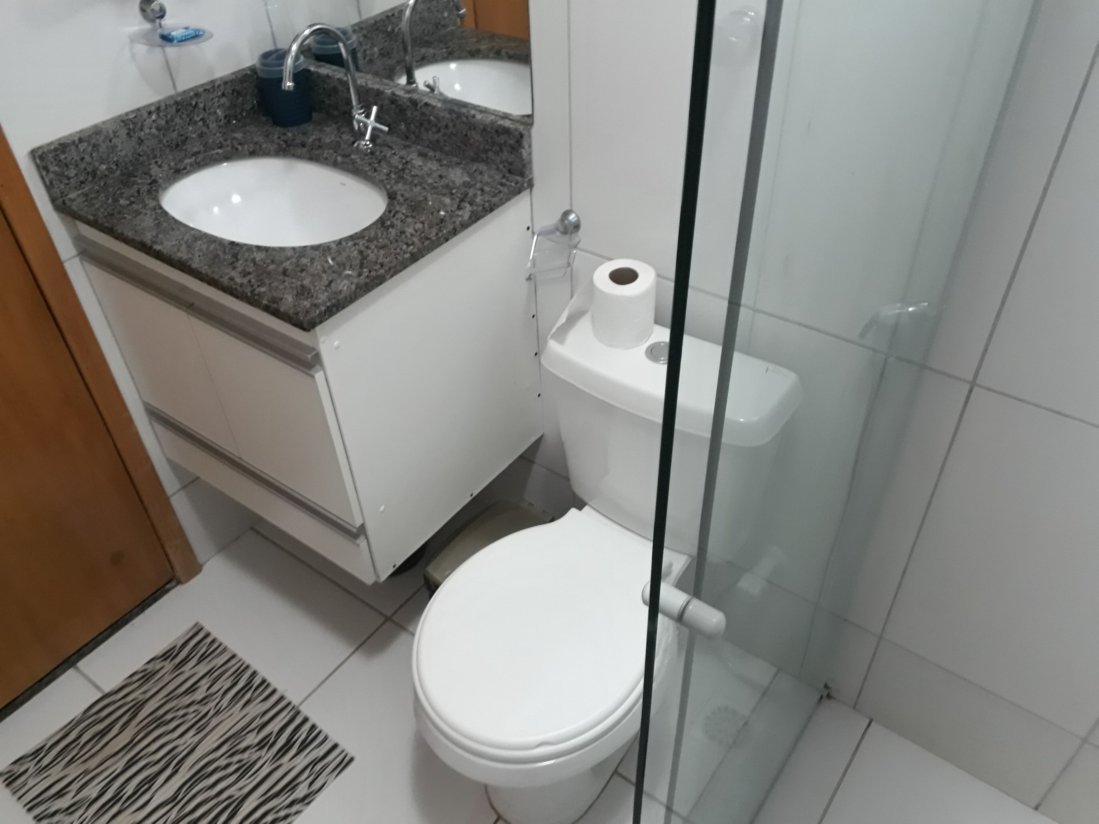A bathroom with a white sink, a toilet, and a shower area.