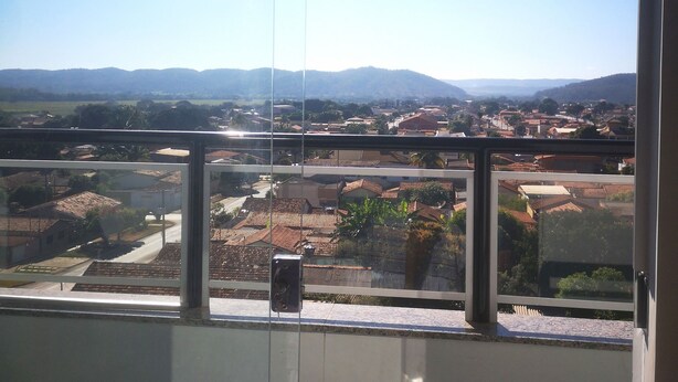 A room with a large window offering a view of a residential area with houses and distant hills. - Unai ApartFlat (Unai)