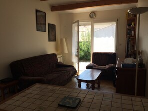 A living room with a sofa, a small table, and a bookshelf.
