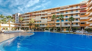 A hotel with a large pool surrounded by lounge chairs and palm trees. - Balcon de Los Gigantes 2A037 (Acantilados de Los Gigantes)