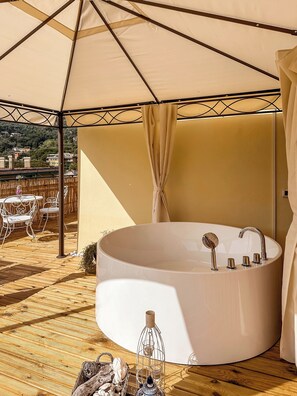 A circular hot tub under a canopy with a view of buildings in the background. - Hotel Villa Anita (Santa Margherita Ligure)