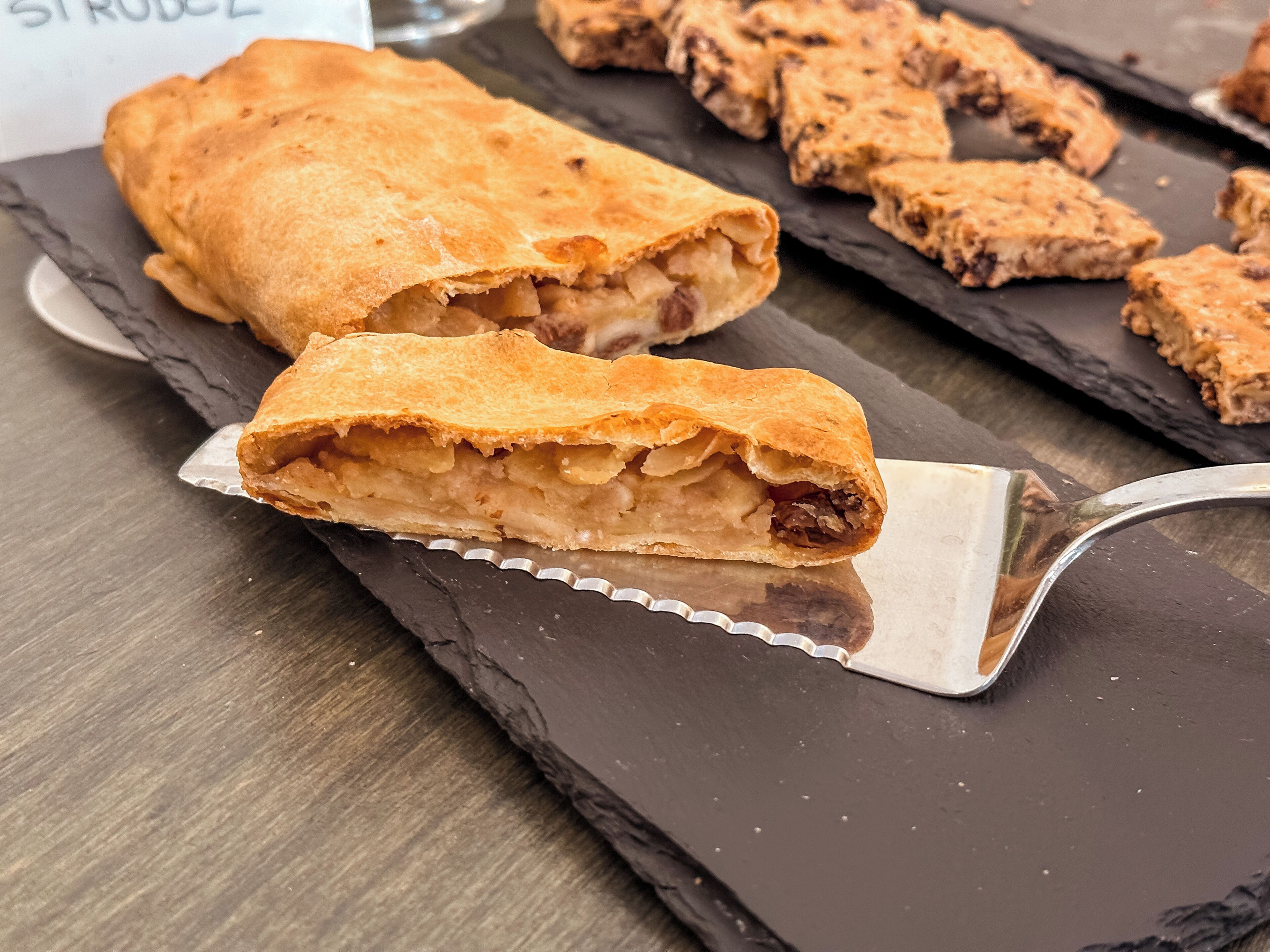 Une pâtisserie à la croûte dorée, coupée en deux pour dévoiler un intérieur à plusieurs couches.