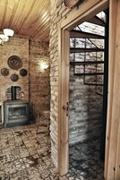 Una habitación rústica con paredes de ladrillo visto, techo de madera y suelo con diseño.