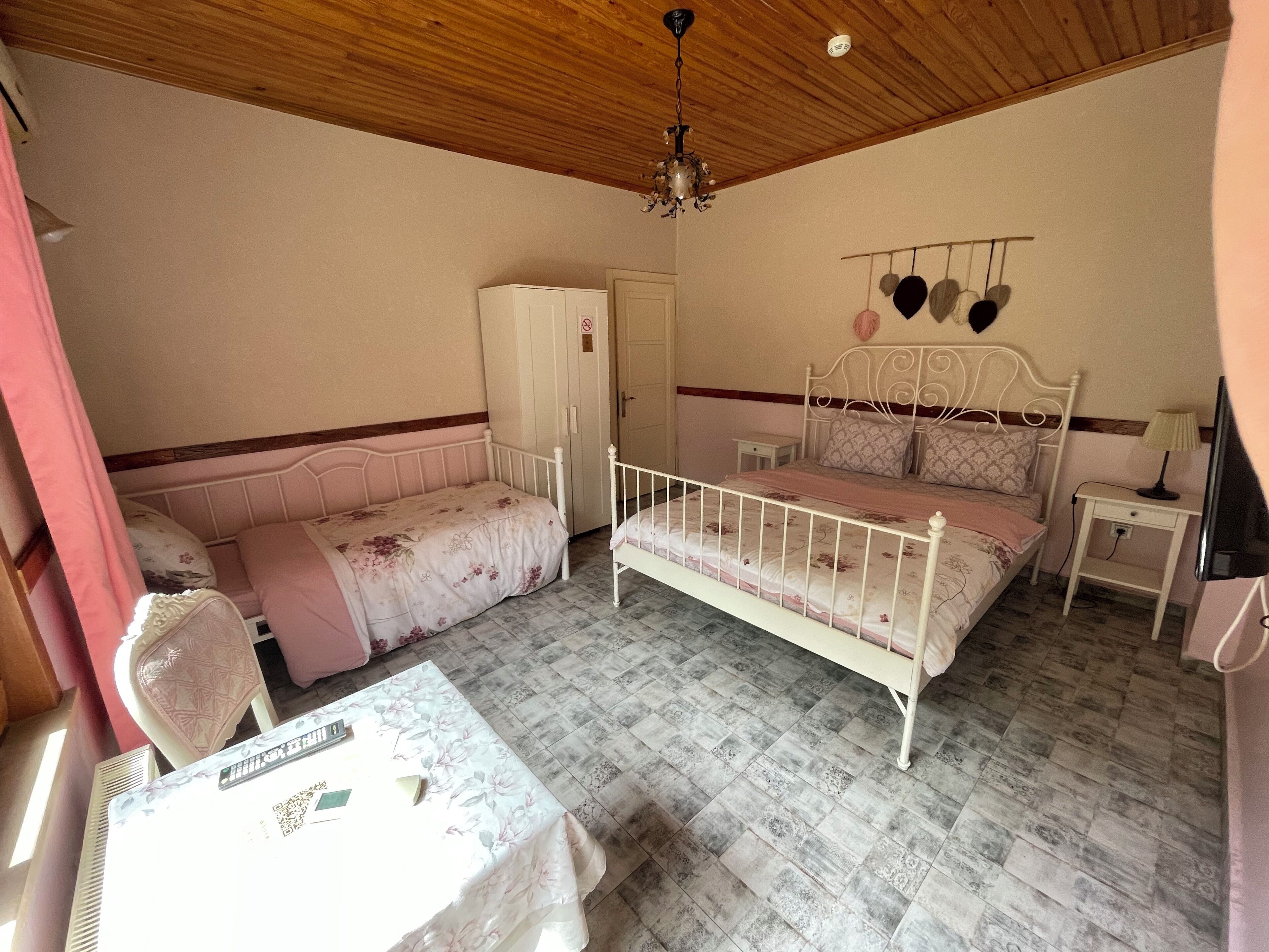 A bedroom with a bed, a bedside table, a wardrobe, and a ceiling fan.